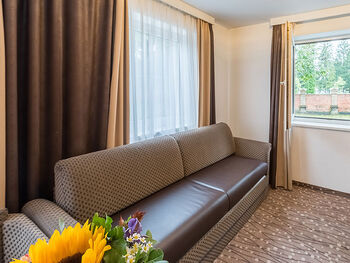 There is a long couch in the hotel room