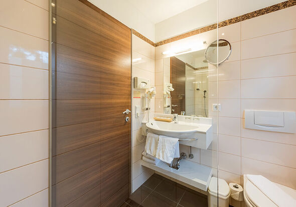 A bathroom with a toilet, a mirror and a sink.
