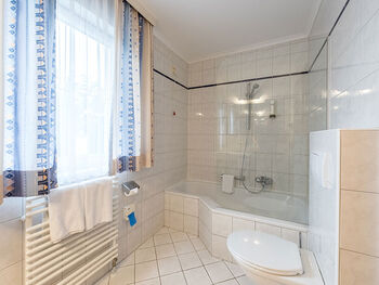 Ein großes Badezimmer mit einer Badewanne und Dusche einer Toilette.