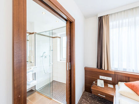 Neben den gemütlichen Bett findet sich das Badezimmer mit einer großen Dusche.