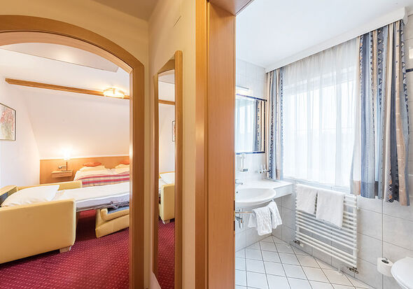 Mit Blick aus dem Flur ins Schlafzimmer und das Bad