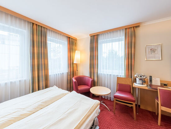 Zwei Doppelbetten sind in diesem Zimmer verfügbar ein Fernseher und viele stuhle befinden sich ebenfalls Zimmer.