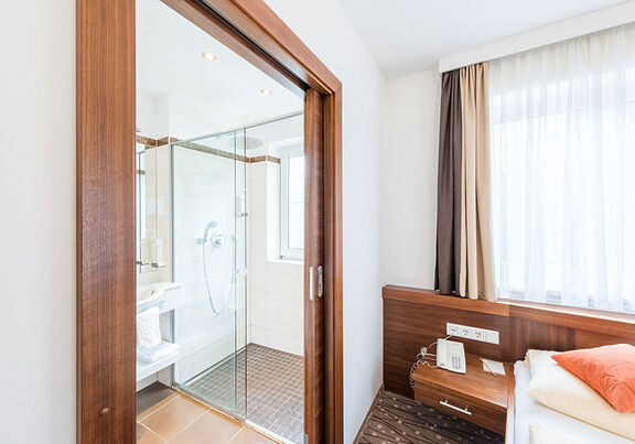 Neben den gemütlichen Bett findet sich das Badezimmer mit einer großen Dusche.