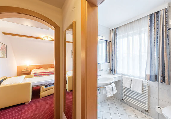 Mit Blick aus dem Flur ins Schlafzimmer und das Bad